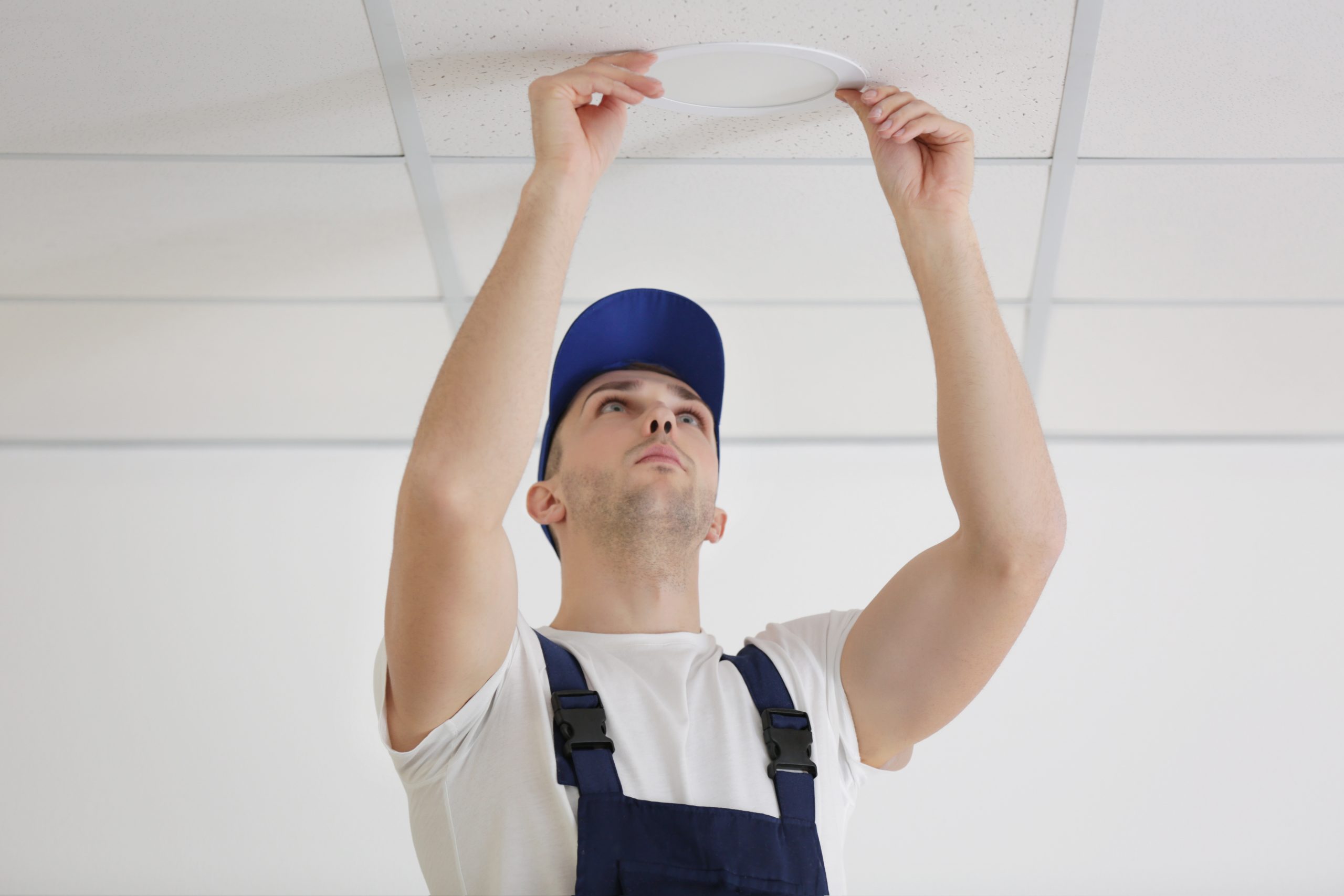 Electrician repairing ceiling light