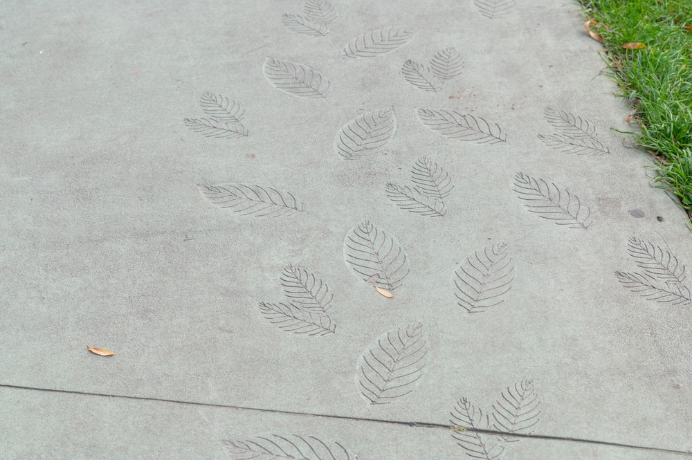 concrete stenciling of leaves on a sidewalk