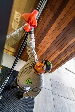technician cleaning a window in a building in portland